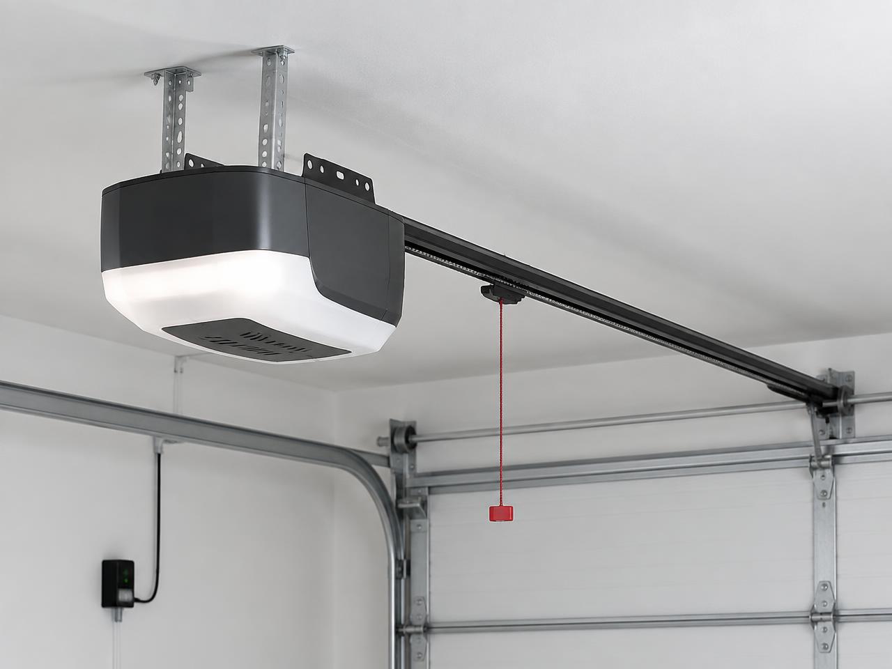 Belt-drive garage door opener mounted on a garage ceiling with rail and safety sensor