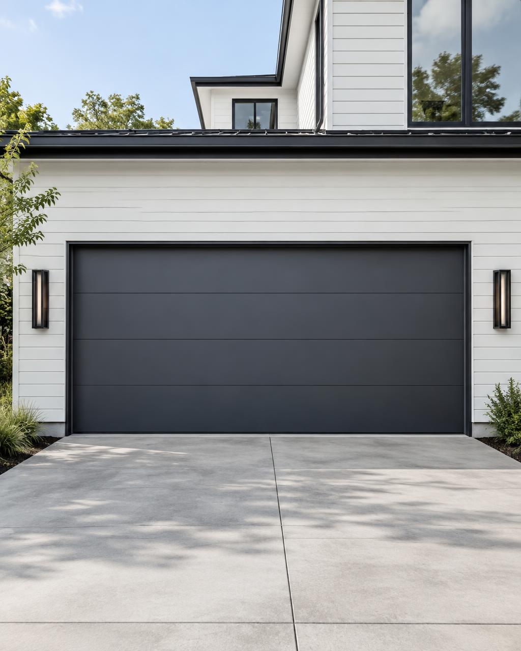 Contemporary dark flush-panel steel garage door on a modern white home